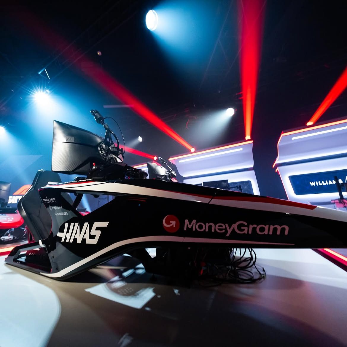 F1 Sim Racing simulator setup under red and blue event lighting