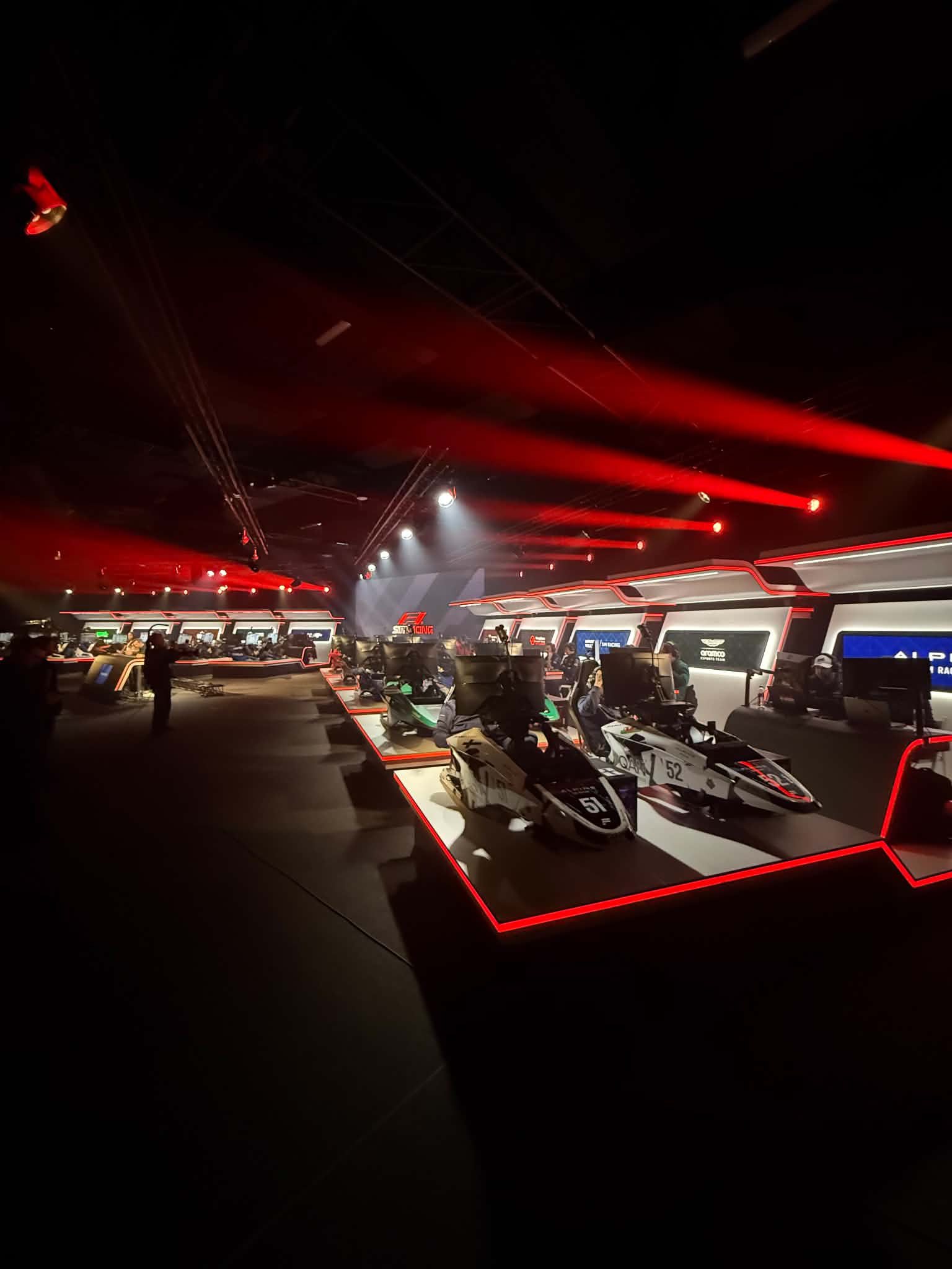 F1 Sim Racing World Championship venue with racing simulators and red event lighting