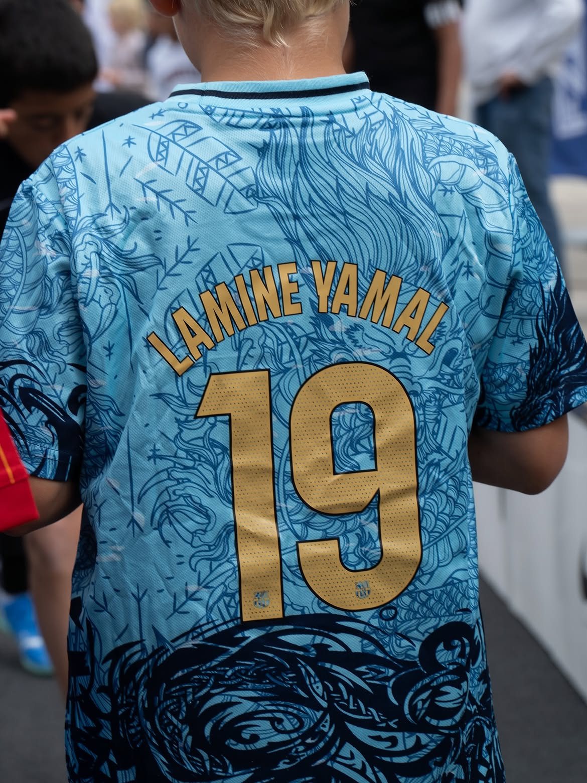 Young football fan wearing a Lamine Yamal shirt at the FUZED Trophy event